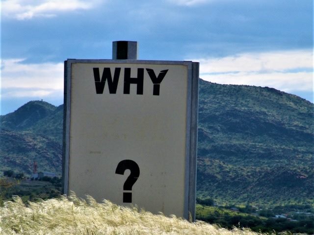 sign with question "why" on top of a mountain