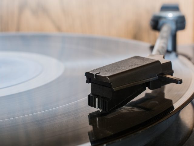 Album on a retro turntable with arm and needle engaged. 