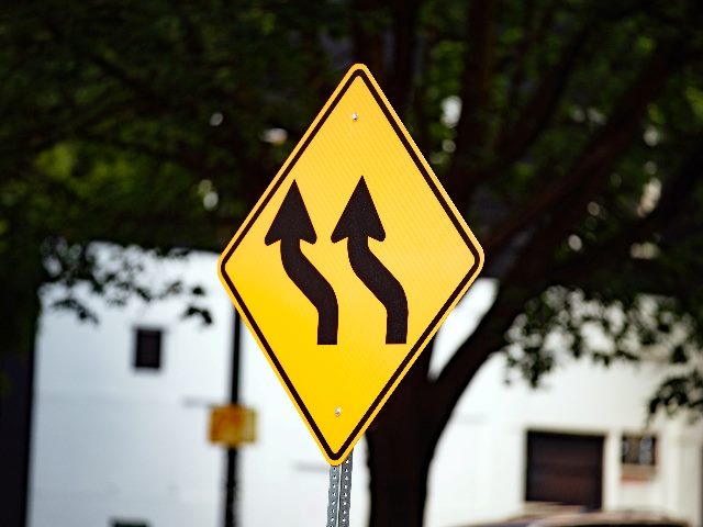  Yellow traffic sign with wavy black arrows, indicating shift left of all lanes.