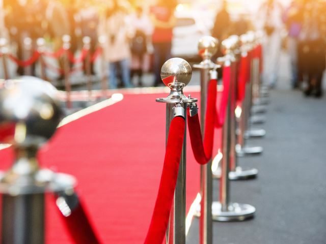 A red carpet guarded by a velvet rope at a theatre entrance - customer VIP concept