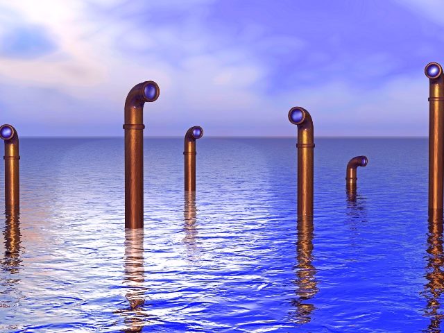 Copper-colored periscopes jut up out of the extremely blue ocean with clouds and sky in the background. 