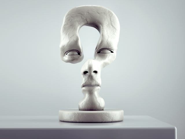 Sculpture of a human face in the shape of a question mark.