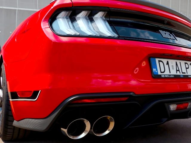 Back bumper and tail lights of red Ford Mustang muscle car.