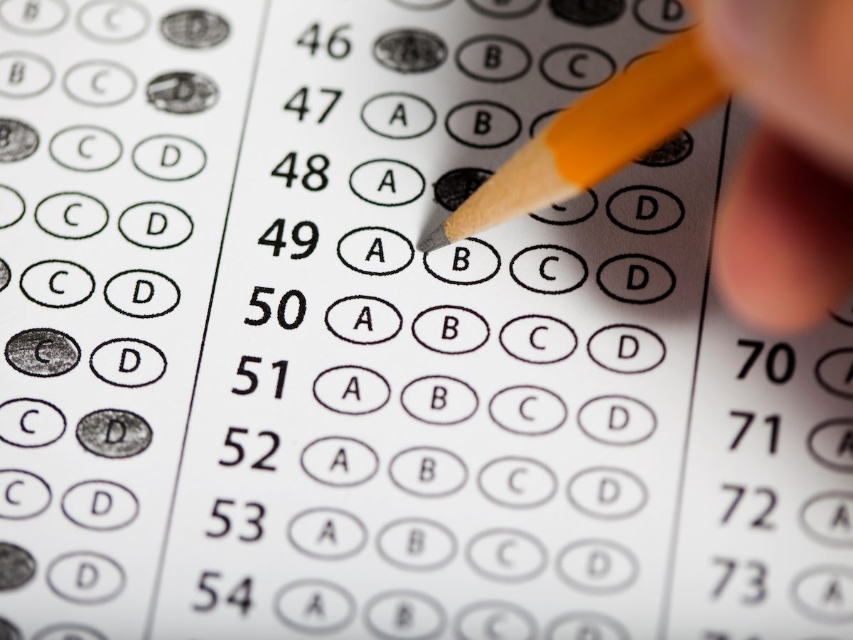 A person filling out answer bubbles on a test sheet
