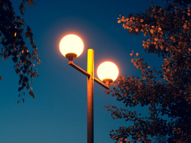 Two street bright streetlights at night.