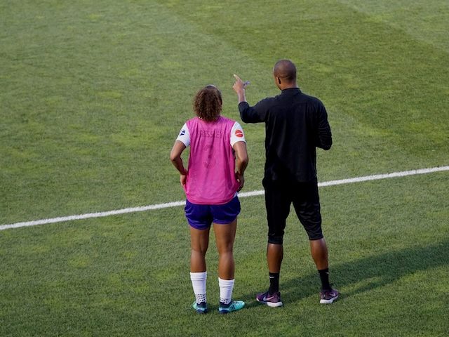coach talking to an athlete on the pitch