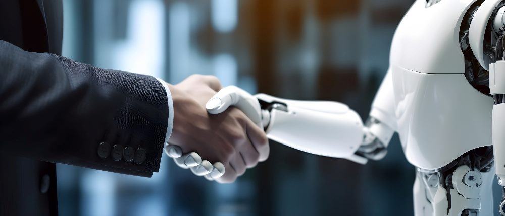 A man in a business suit and robot shake hands, with only their torsos and arms visible, suggesting the importance of the ethics of AI.