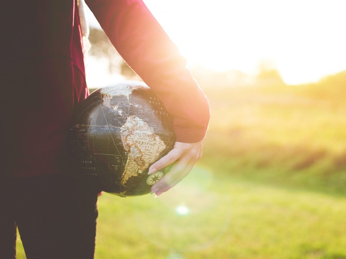 Shot from behind a person holding in right hand a globe.