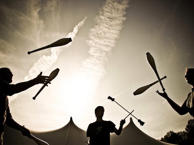 three people juggling together