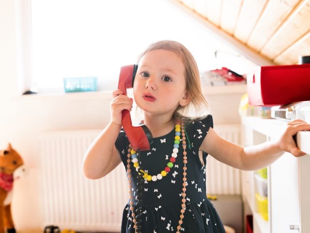 Little girl talking on a toy phone