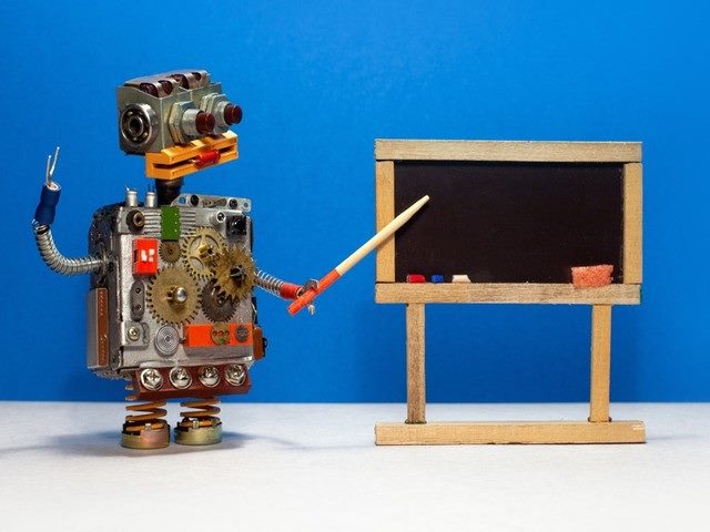 Robot pointing to a chalk board.
