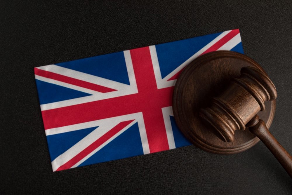 UK red, white and blue flag and gavel lying on a table suggesting recent report on AI foundational models.