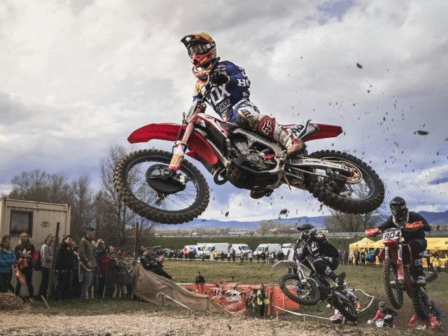 A motocross rider jumps through the air.