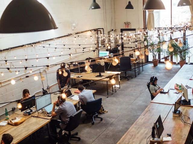 open plan office with multiple people working in front of computer monitors