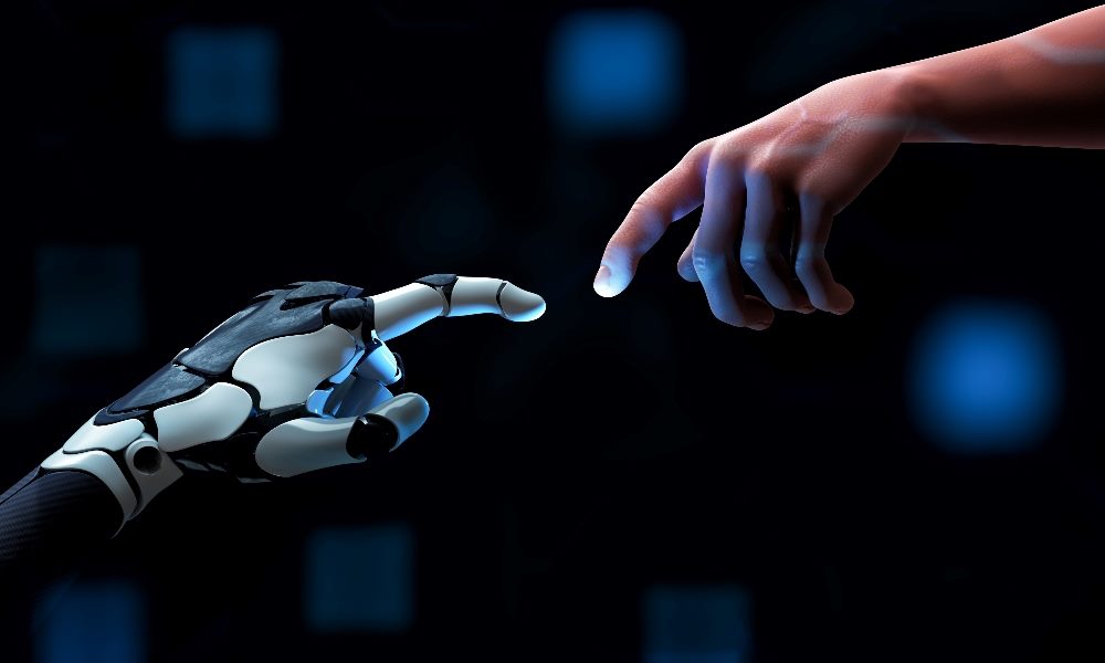 A human hand and a robot hand reach toward each other on a dark blue background backlit with light blue suggesting the need for the human touch in AI customer experience.