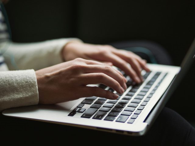 An employee types on a laptop computer.