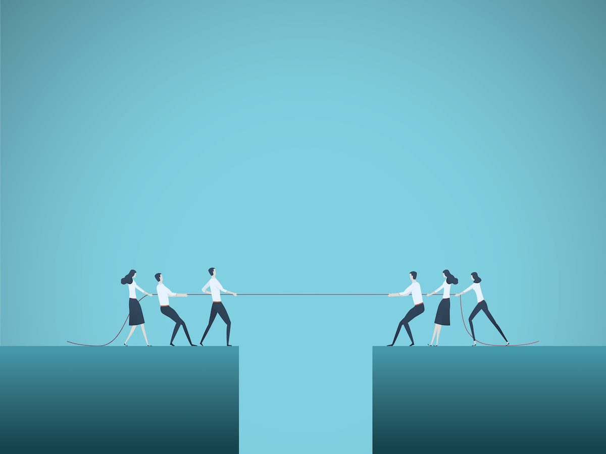 Business people playing tug of war with a crevice/pit inbetween 