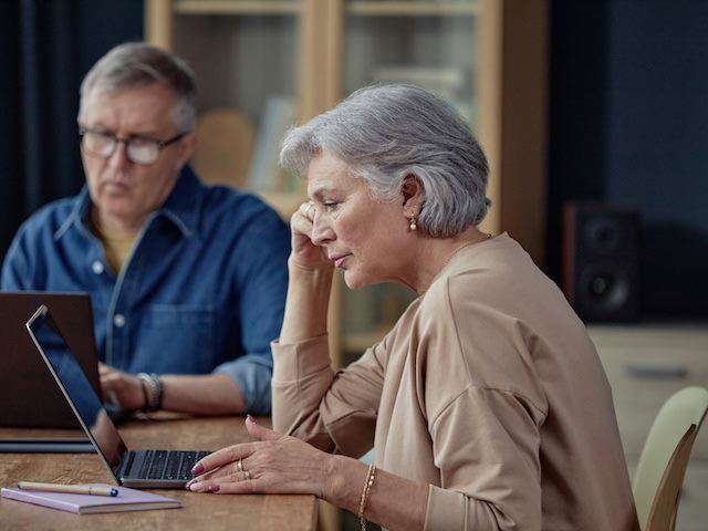 older professional focused on a laptop, very focused