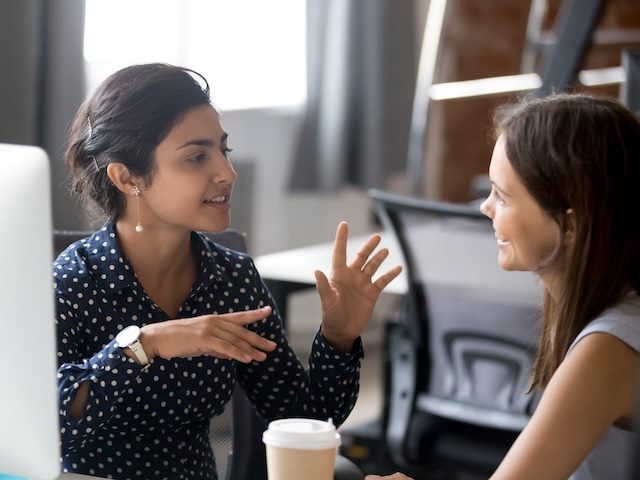 two coworkers chatting over coffee