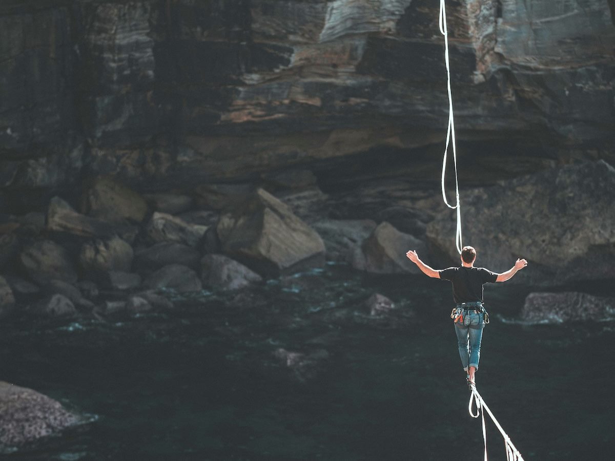 balancing on a tightrope while walking across a body of water