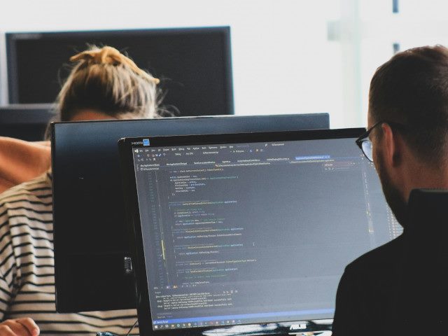 Software engineers write code on a computer.