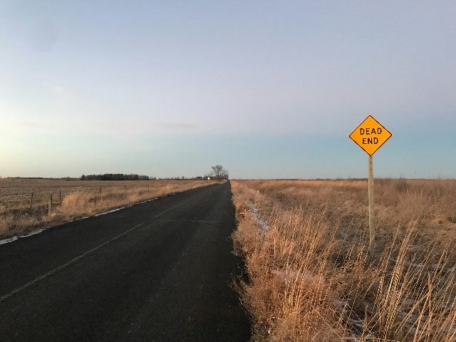 Dead end sign on an empty street in desert-like environment.