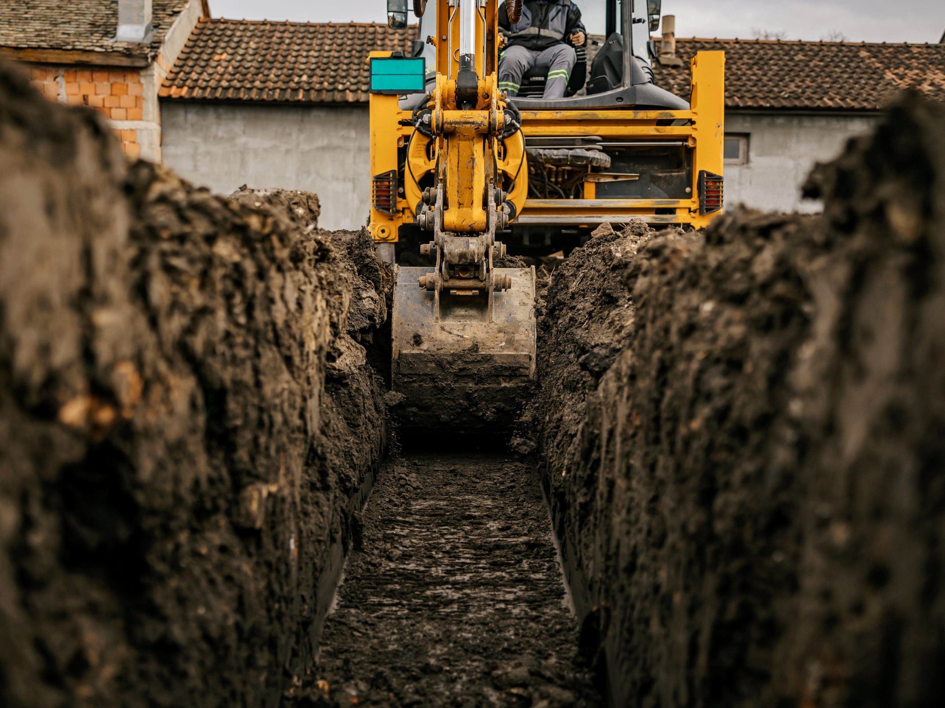 A yellow and black  backhoe digging soil and making foundation at construction site.suggesting the need for a foundation for hyperpersonalization. 