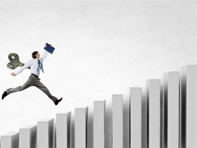 IT worker with wind up key in his back leaping up a performance chart - AI concept