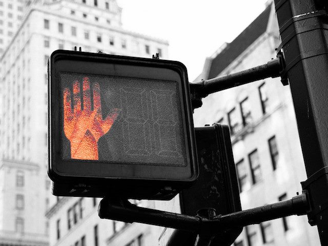 street signal using a hand to mean "don't walk"