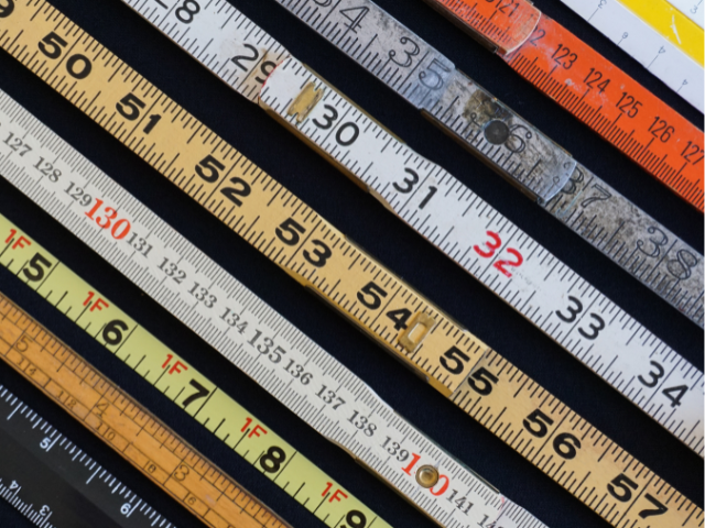 Multiple tape measures and rulers laid out next to each other 