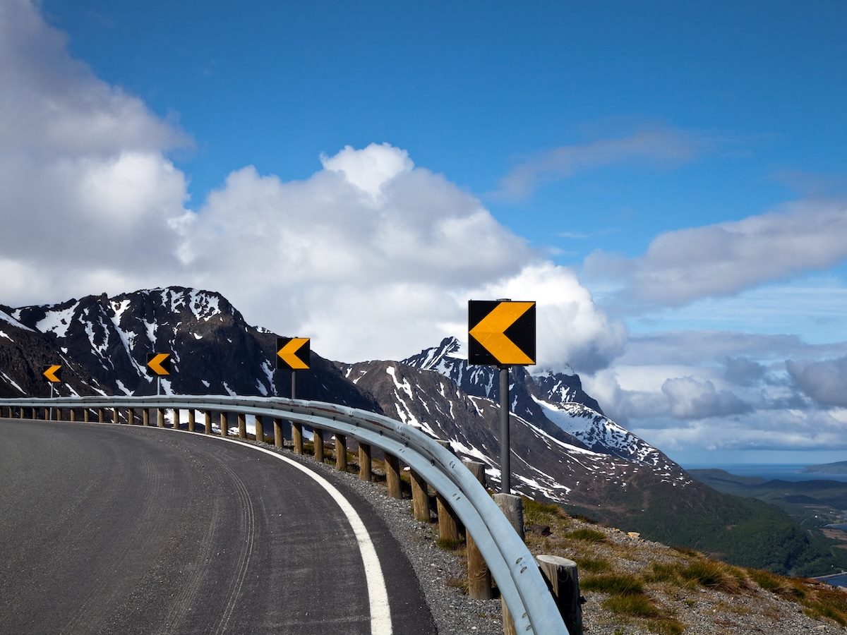 A curve in the road with yellow turn warning signs