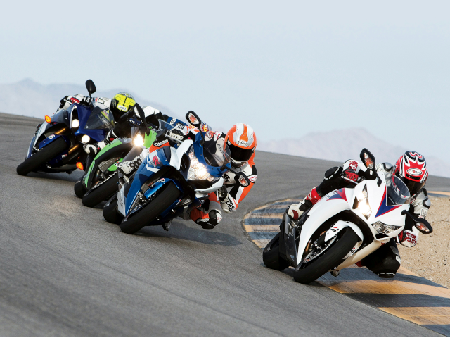 Motorcyclists turn on a race track.