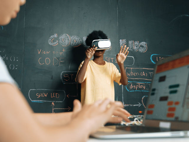 A student in a classroom using a VR headset 