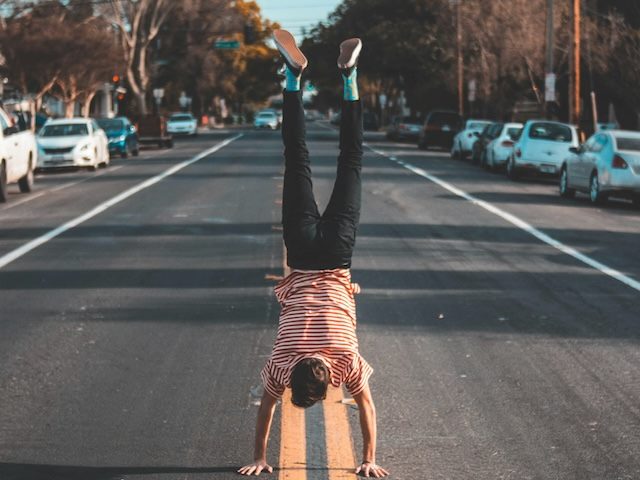 a person doing a handstand in the middle of a road