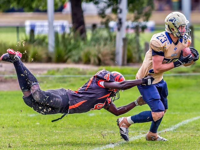 Football player tackling opponent