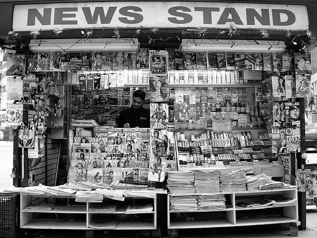An outside news stand in black-and-white.
