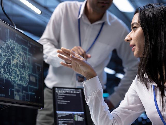 two colleagues working on a problem in a workplace