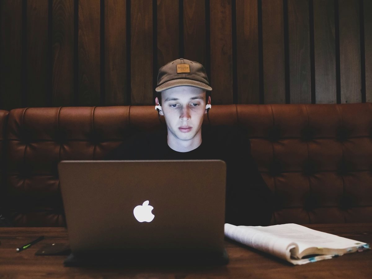 isolated worker, earphones on, staring at laptop