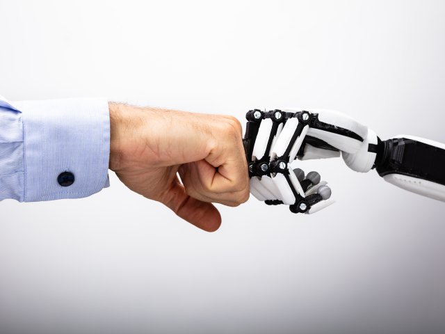 Human Hand And Robot Making Fist Bump -  AI and workers concept