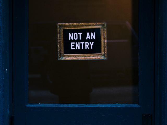 closed blue door with a sign saying not an entry