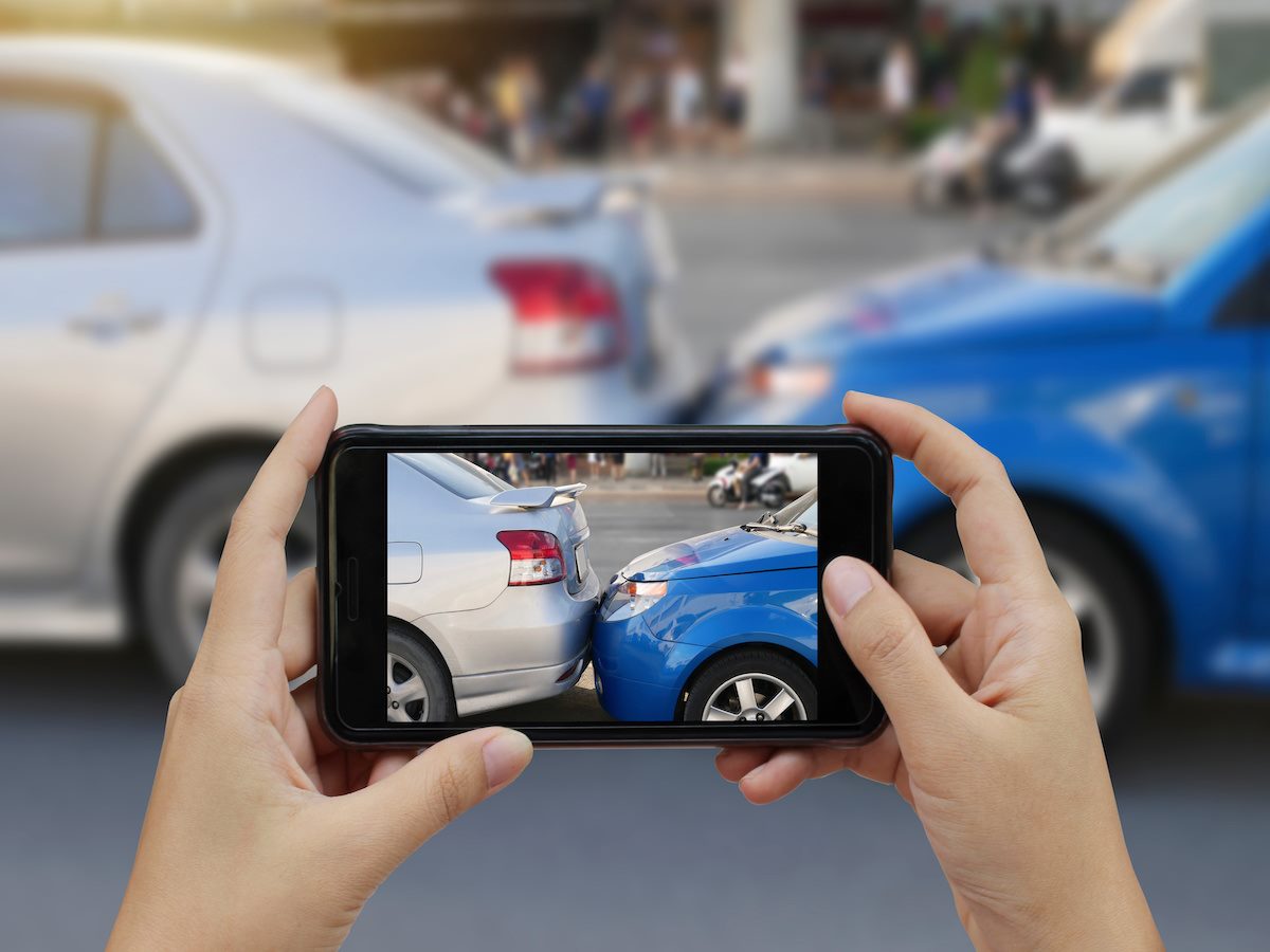 A person taking a photo of a car accident