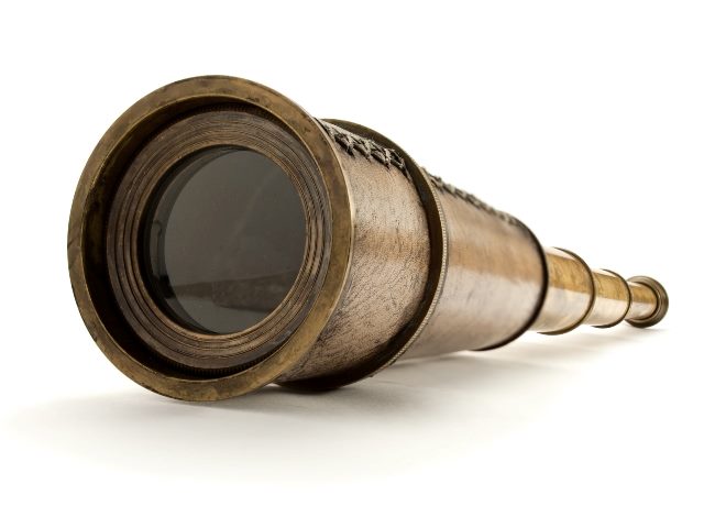 Closeup of a vintage brass spyglass on a white background symbolizing how causal AI can lead to deeper marketing insights. 