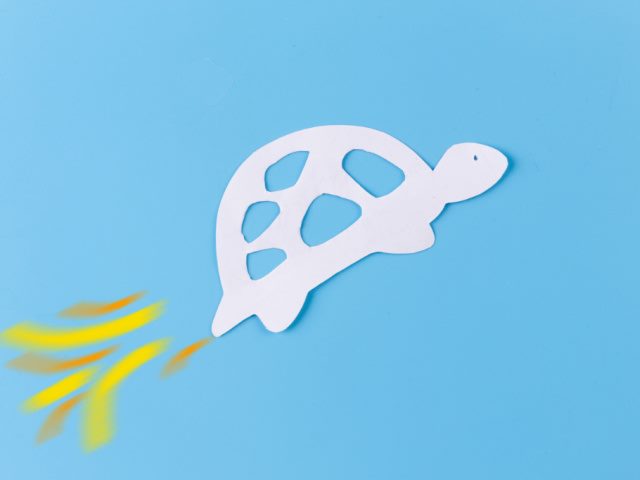 photo illustration of a turtle with a rocket tail on a light blue background