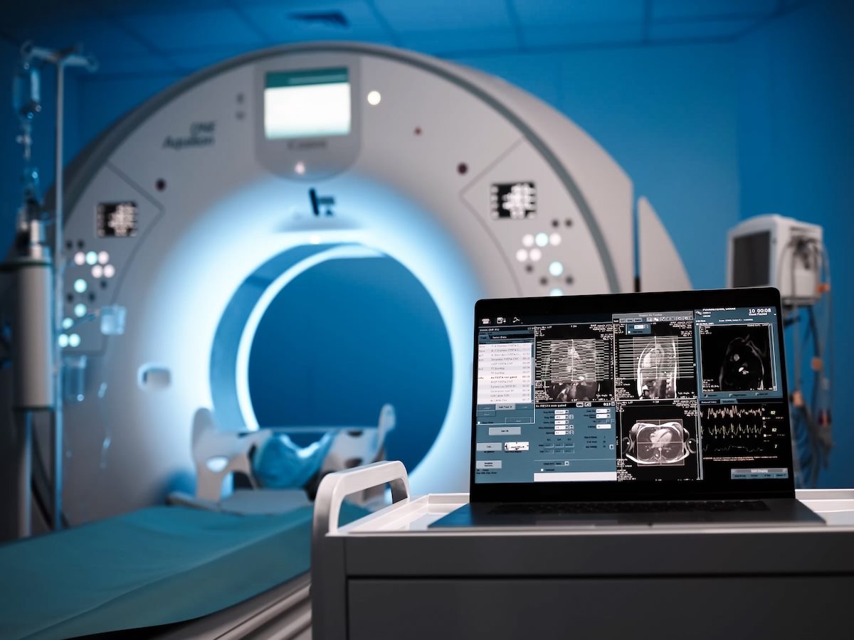 A screen displaying CT or MRI scan images against the backdrop of modern medical equipment