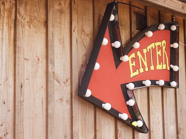enter sign, in the shape of an arrow surrounded by lightbulbs
