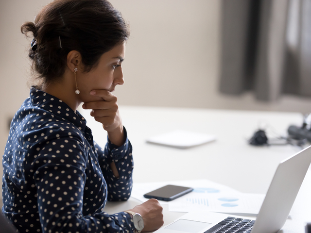 Concentrating businesswoman analyzing the results and doubting their accuracy - predictive analytics concept