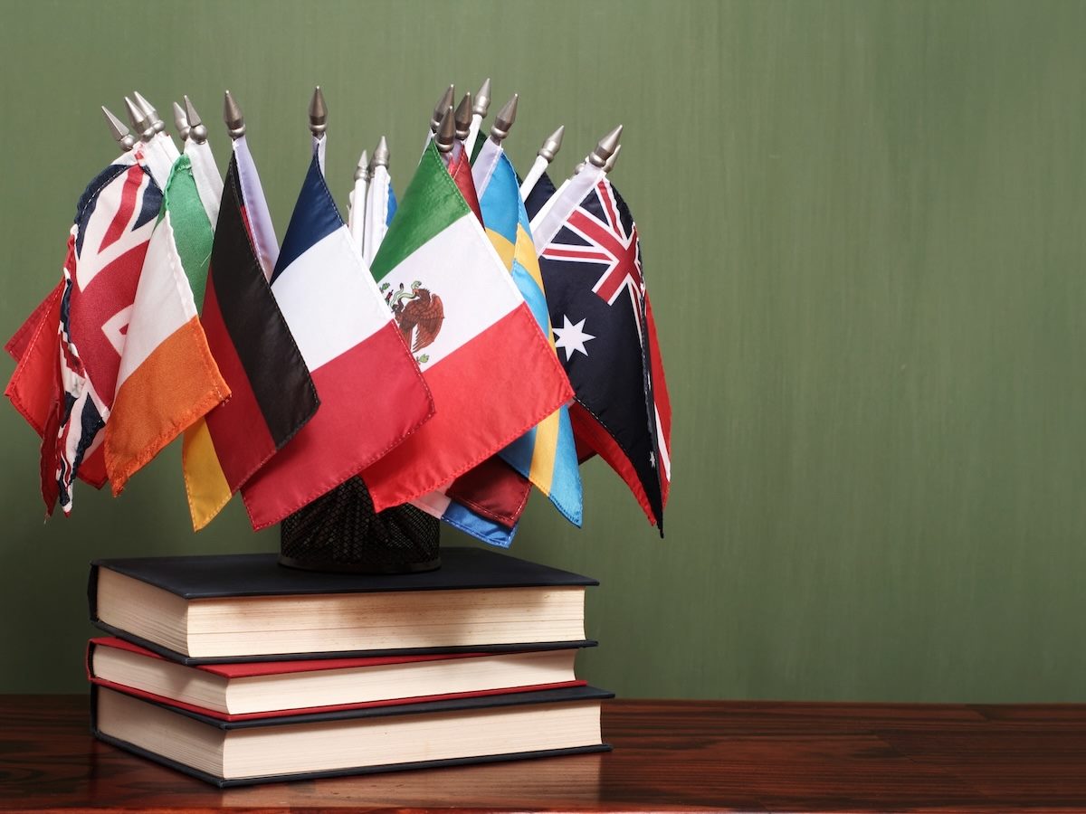 world flags on top of a stack of books