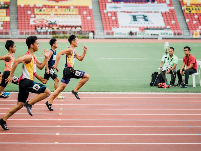 a group of boys running a close race