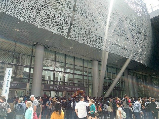 People waiting outside of a "Salesforce Transit" building.