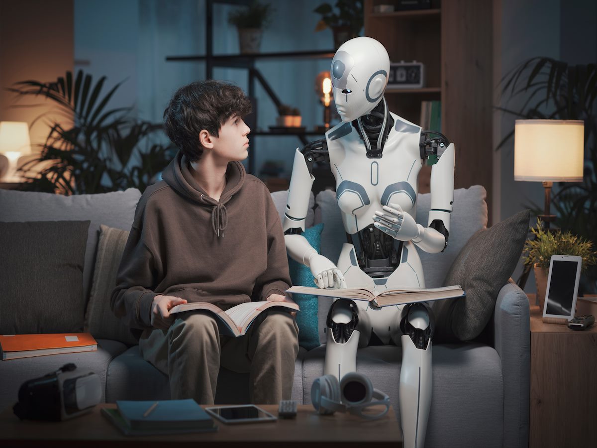 A robot with a book sitting next to a person on a couch